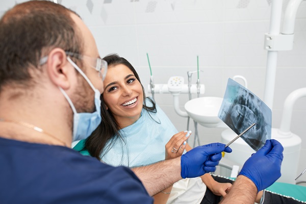 people, medicine, stomatology and health care concept - happy male dentist showing work plan to woman patient at dental clinic office